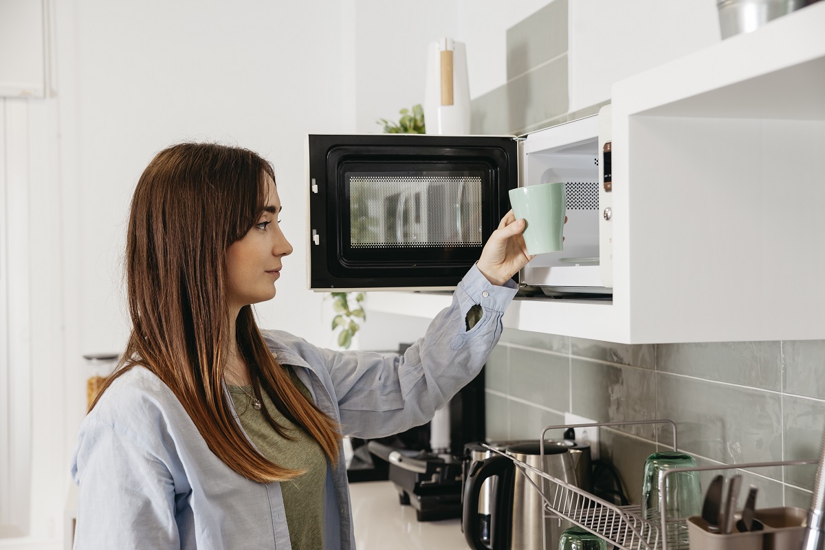 casual girl using microwave heat cup
