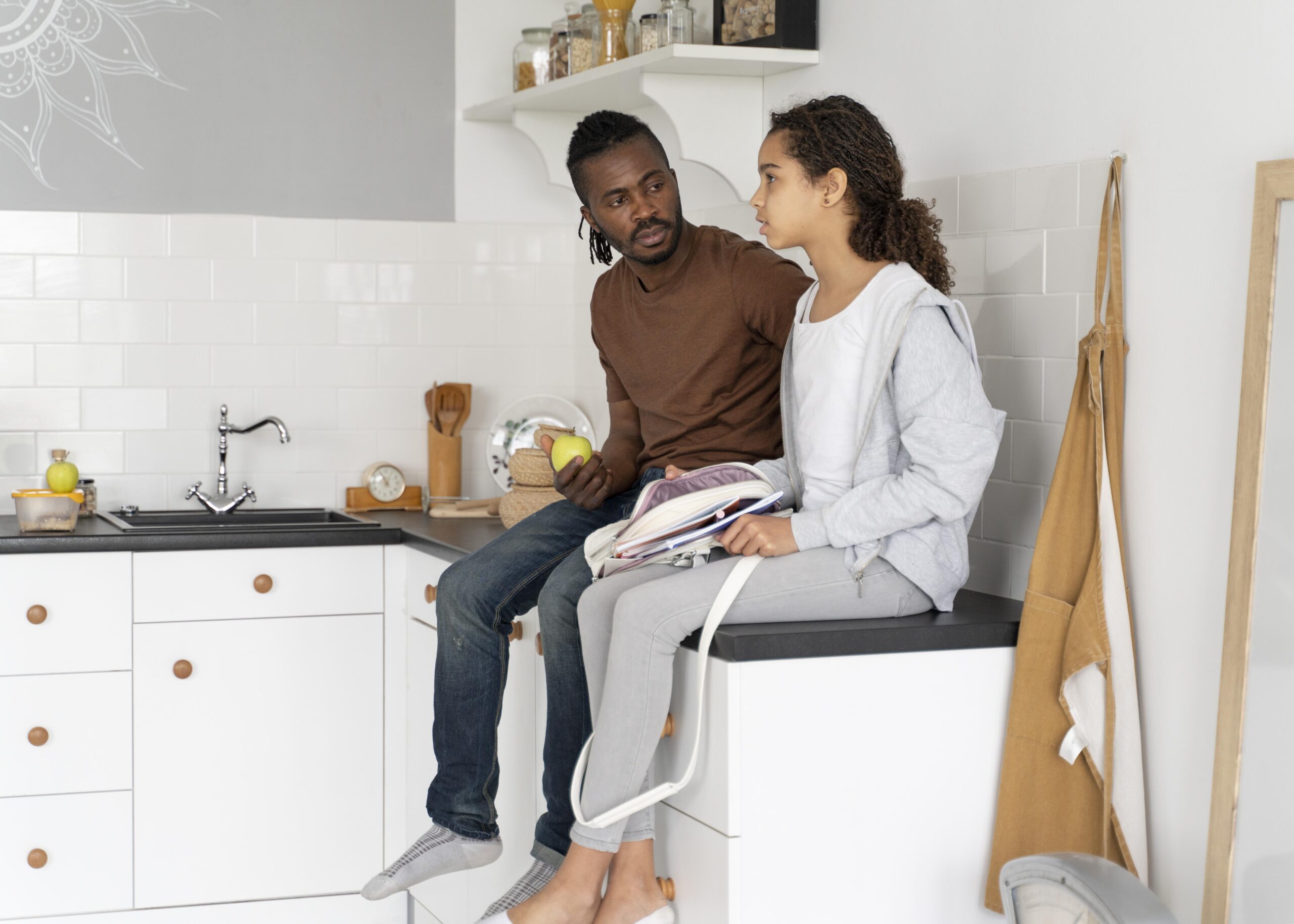 father daughter sitting kitchen counter
