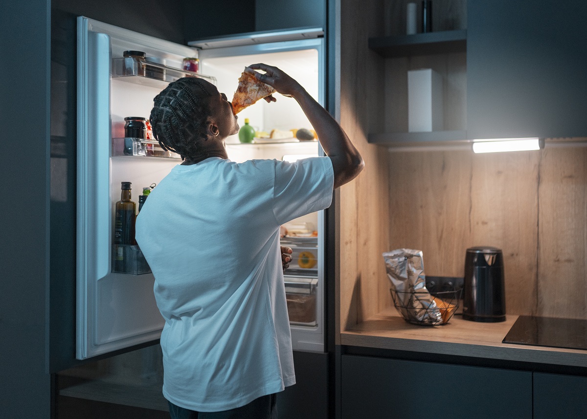 young man having snack middle night home fridge
